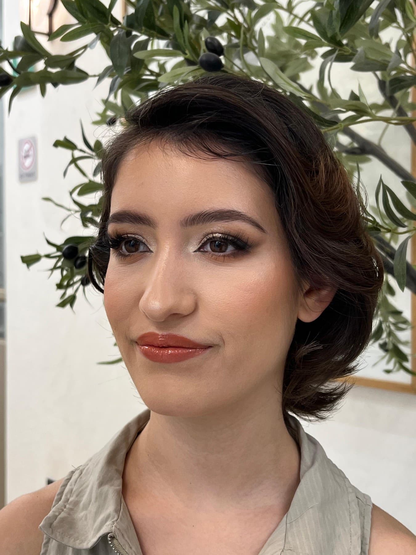 Maquillaje de noche visto de cerca: ojo ahumado en tonos café, piel luminosa y labial terracota